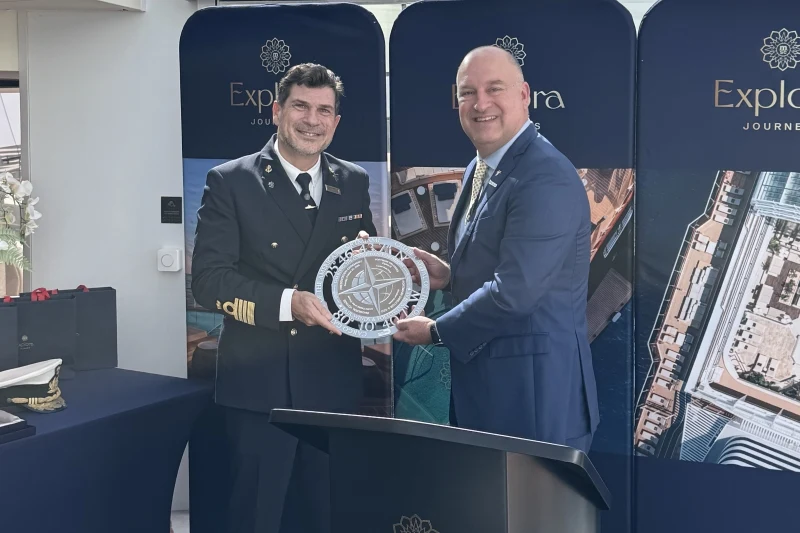 The photo shows the plaque exchange ceremony in Miami between the ship's captain and a representative, matching the article text.