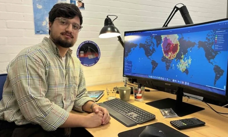 The image features researcher Kian Bostani Nezhad seated at his desk next to a monitor displaying the SAT-JAM satellite tracking map, directly matching the article content.